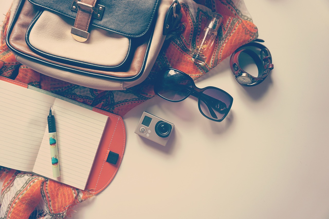 A travel bag with go pro and sunglasses.